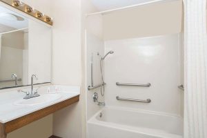 Accessible bathroom vanity and bath tub with grab bars