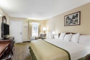 King bed across from TV and dresser at Baymont by Wyndham Greenwood