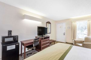 King bed end across from flat screen TV, microwave, and mini fridge at Baymont by Wyndham Greenwood